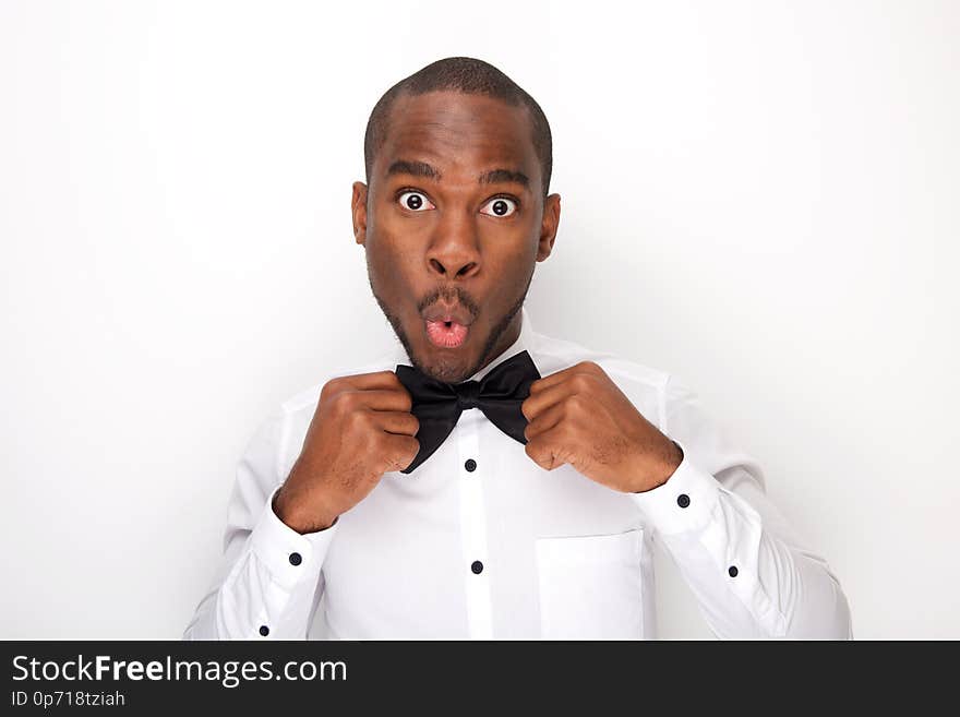 African american man making a face white adjusting bowtie