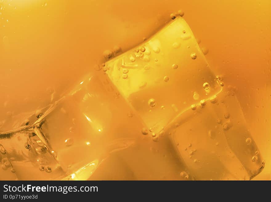 Blurred or defocused image of ice cubes in orange summer drinks. Blurred or defocused image of ice cubes in orange summer drinks