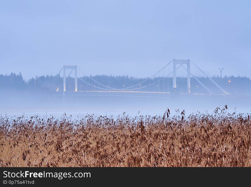 Kirjalansalmen bridge in Parainen, Finland on a foggy evening with lights of traffic.