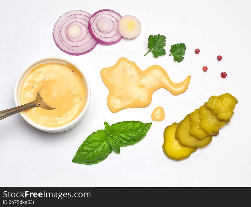 Sauce for hamburgers Basil leaves and parsley and pepper sliced onion and pickled cucumber white background selective focus