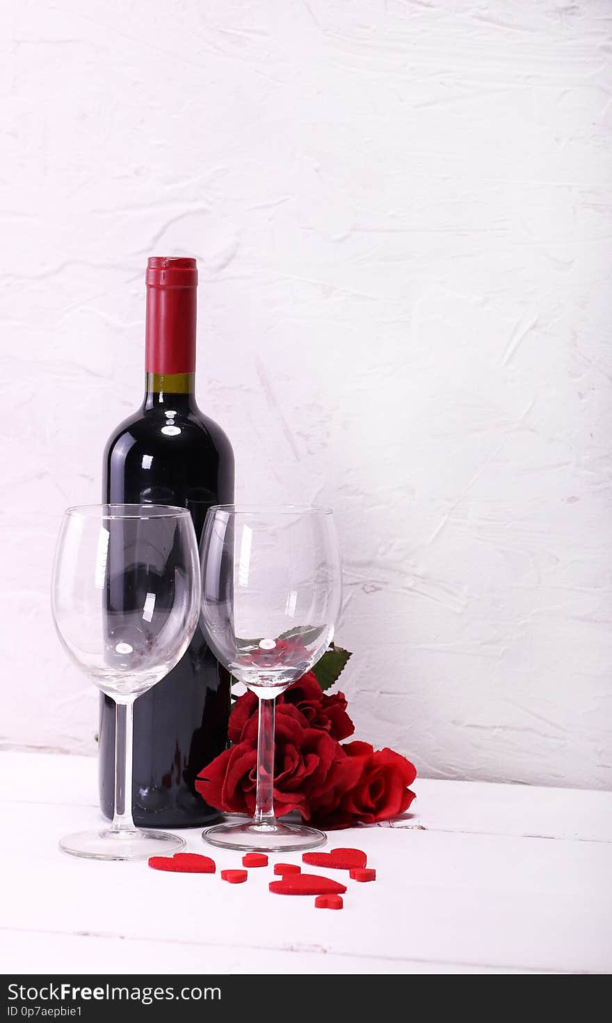 Happy Valentine`s Day with red wine, red roses, wine glasses, white background and hearts in love. Happy Valentine`s Day with red wine, red roses, wine glasses, white background and hearts in love