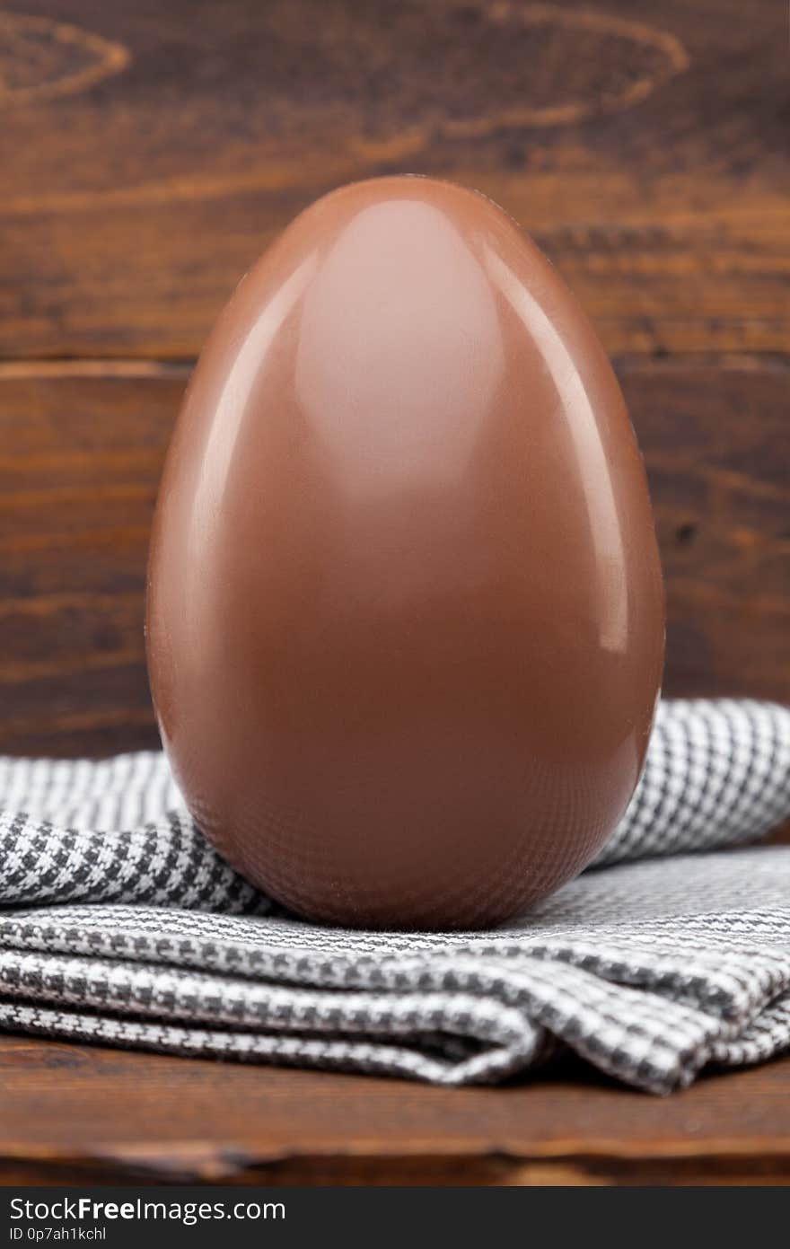 Chocolate Easter holiday egg on rustic backround