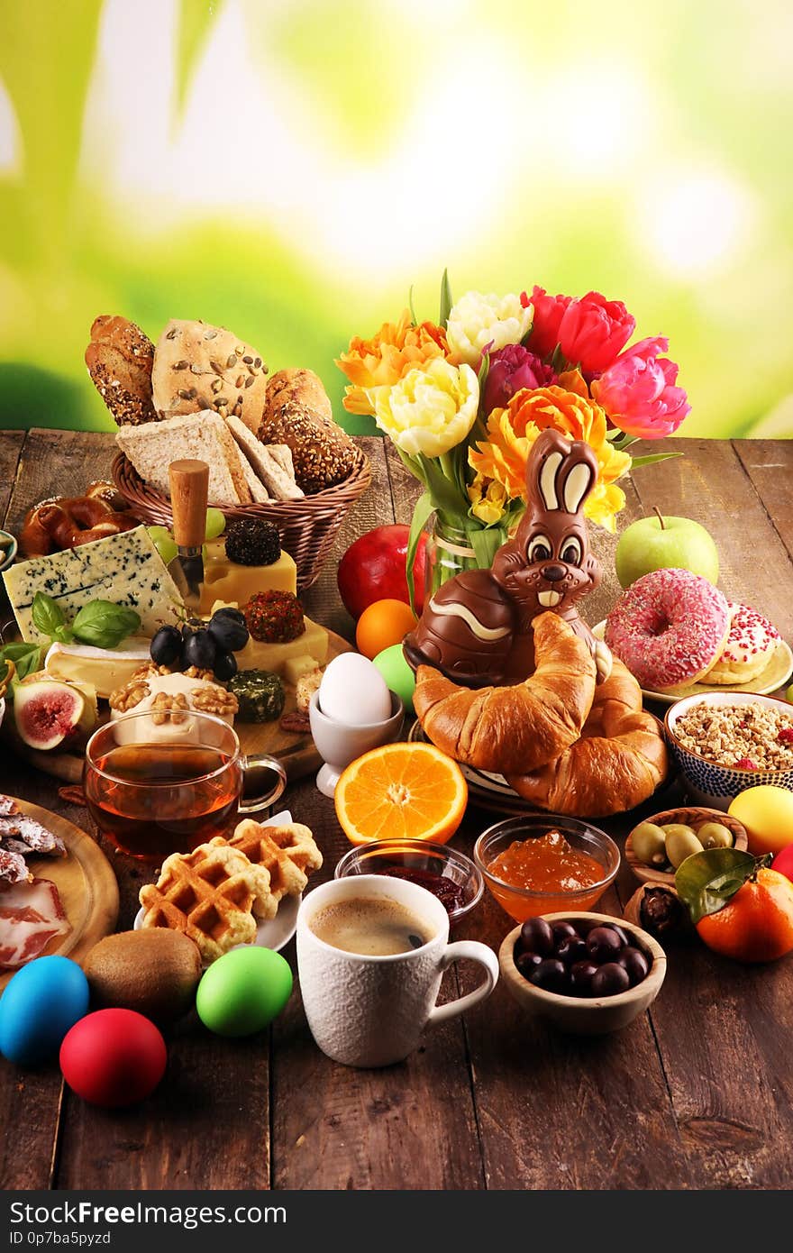 Breakfast on table with bread buns, croissants, coffe and donuts