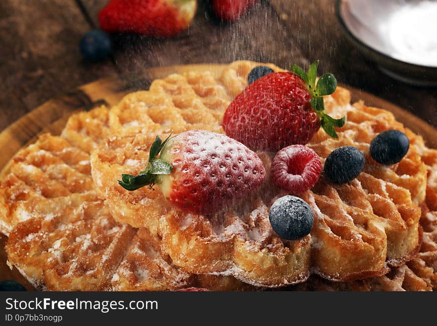 Waffle. Traditional belgian waffles with fresh fruit and powder sugar on wood