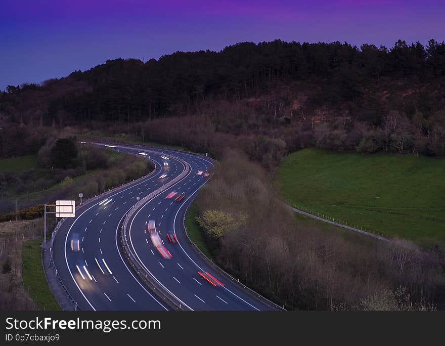 Car lights on the road at night heading to the city, Basque Country