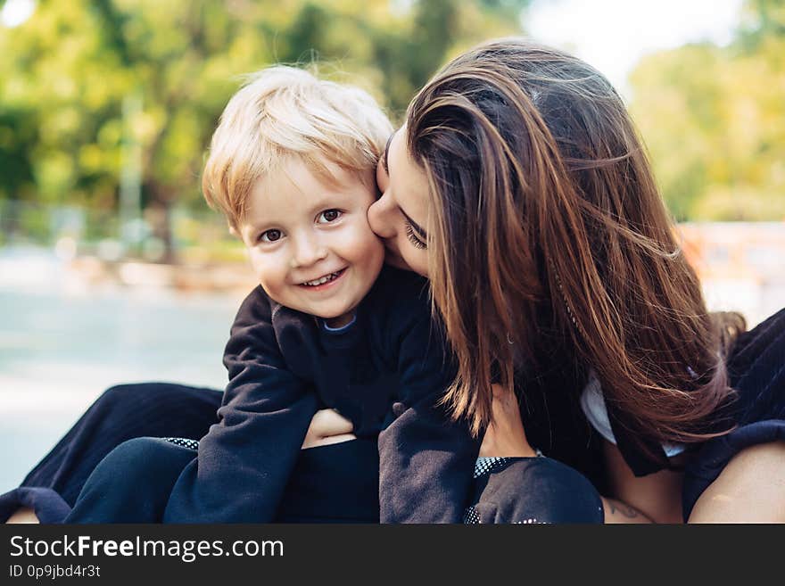 Young mother is playing with her child outside in the park