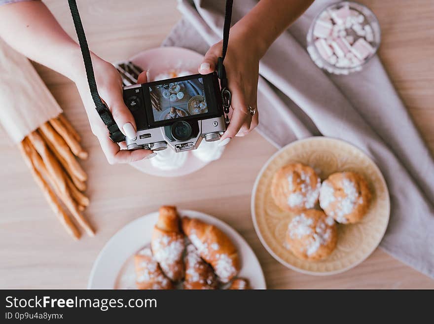 Food blogging hobby. Sweet homemade bakery assortment. Woman shooting fresh cakes and pastries from above. Food blogging hobby. Sweet homemade bakery assortment. Woman shooting fresh cakes and pastries from above.