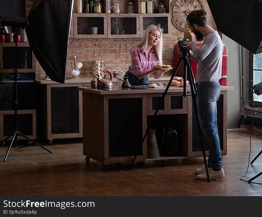 Homemade cooking. Baking hobby. Backstage photography. Man shooting women with fresh cakes and pastries. Homemade cooking. Baking hobby. Backstage photography. Man shooting women with fresh cakes and pastries.