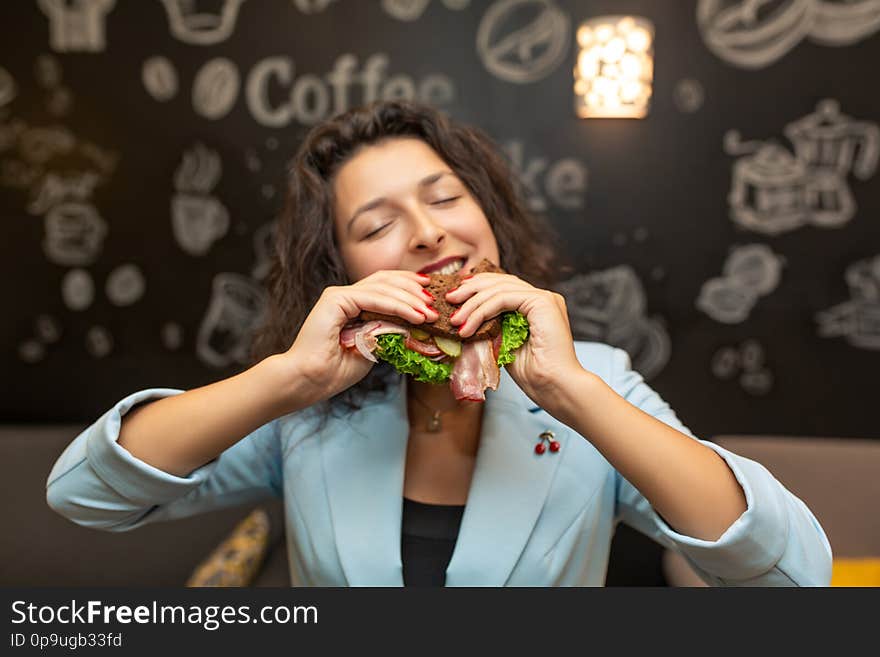 Closeup portrait of hungry young caucasian woman, bite sandwich