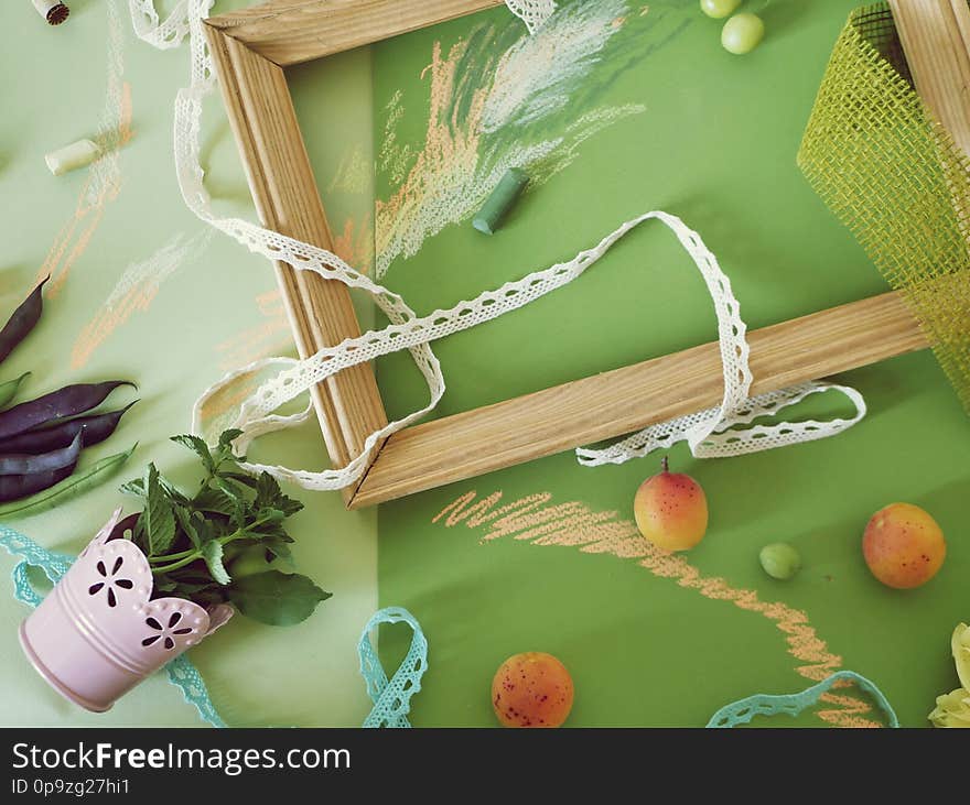 Decorative seasonal composition of fruits, decor, greens and a white frame on green toned paper