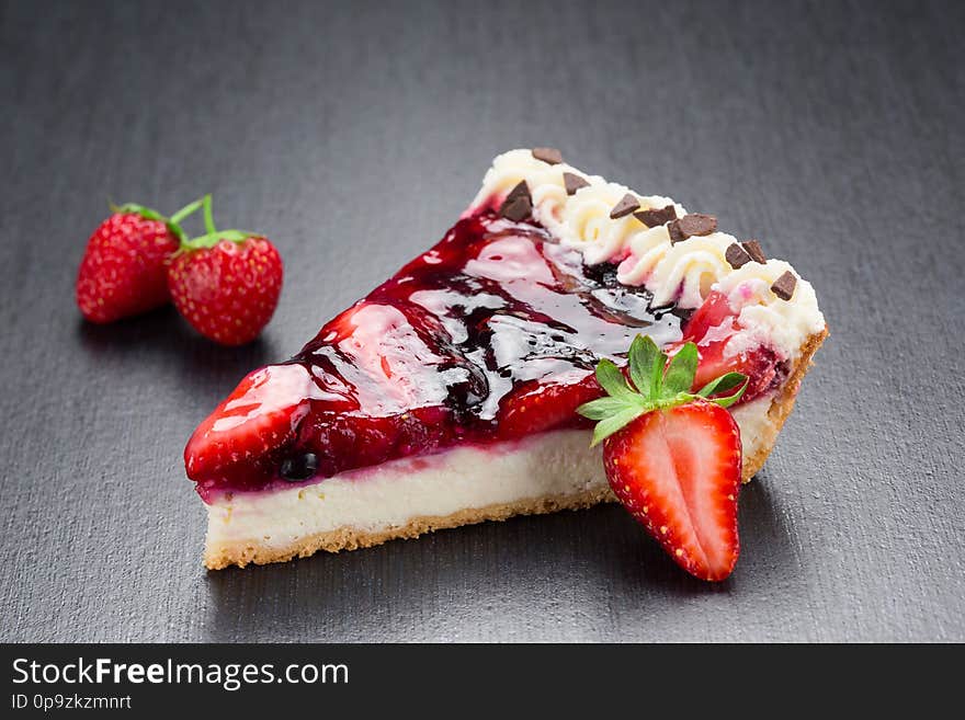Strawberry cheesecake slice on a dark background. Strawberry cheesecake slice on a dark background