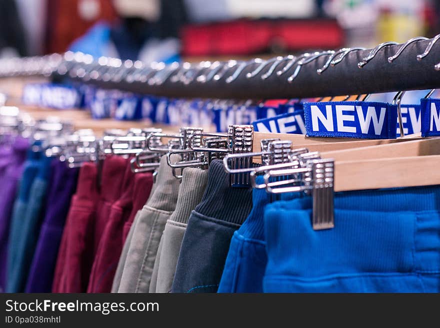 New pants on the hanger in the store. Retail sales. Shopping center. New clothes. Colorful background design