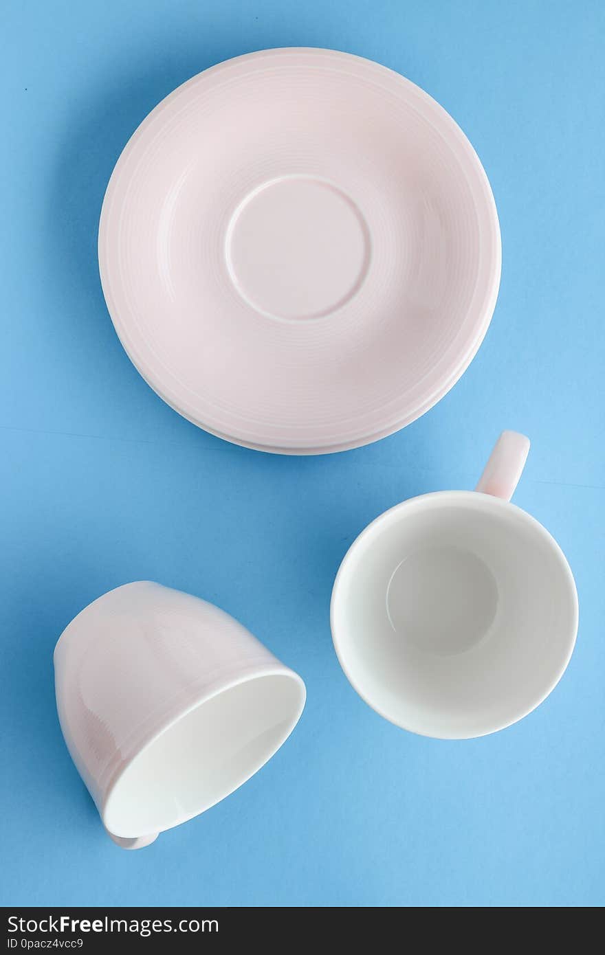 Empty cup and saucer on blue background, flatlay