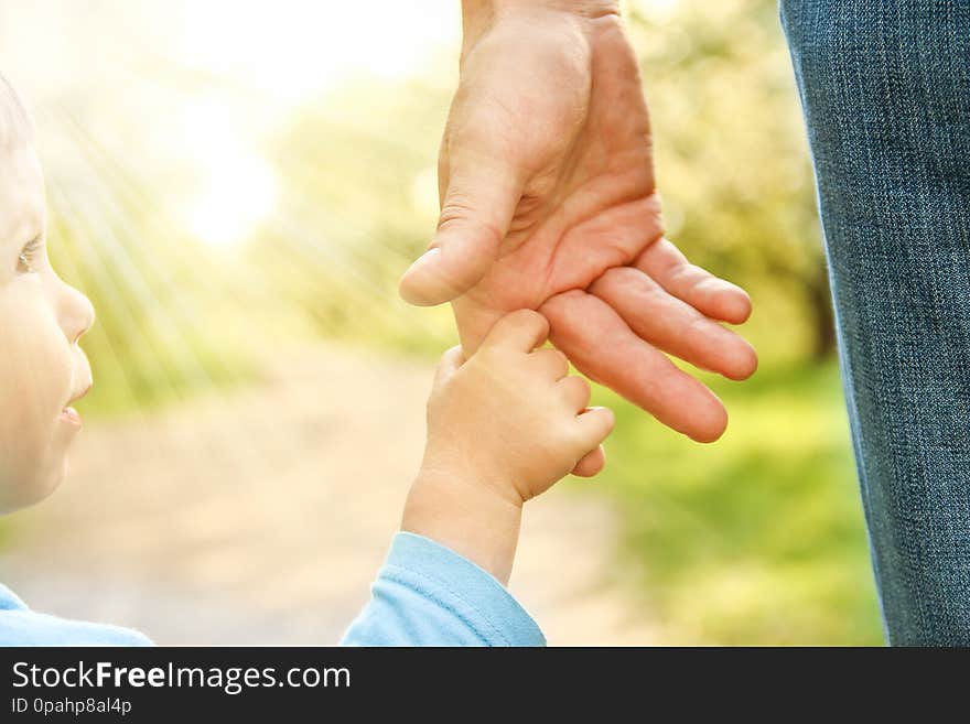 The parent holding the child`s hand with a happy background