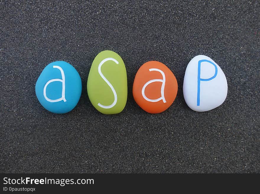 Asap, as soon as possible, acronym, composed with multi colored sea stones over black volcanic sand