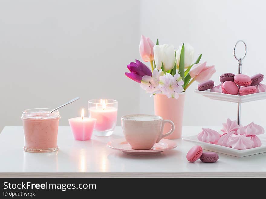 Tulips in vase and cup of coffee with dessert