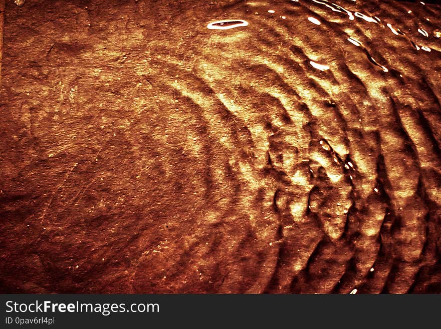 Flowing liquid on gold surface - luxury background and abstract design concept. Golden source