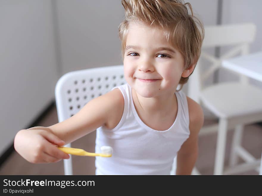 Boy cleans his teeth in the morning and plays with a toothbrush.