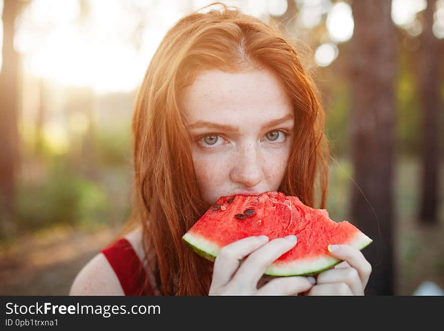 Happy young woman eating watermelon on the nature. Youth lifestyle. Happiness, joy, holiday, beach, summer concept