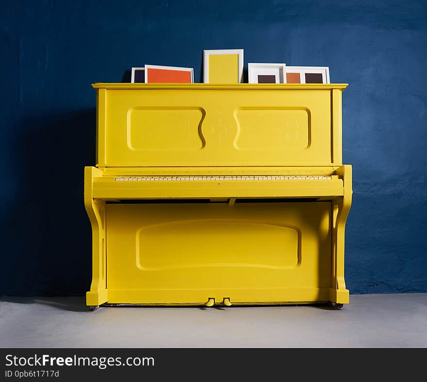 Old yellow piano on blue  happy. Old yellow piano on blue  happy