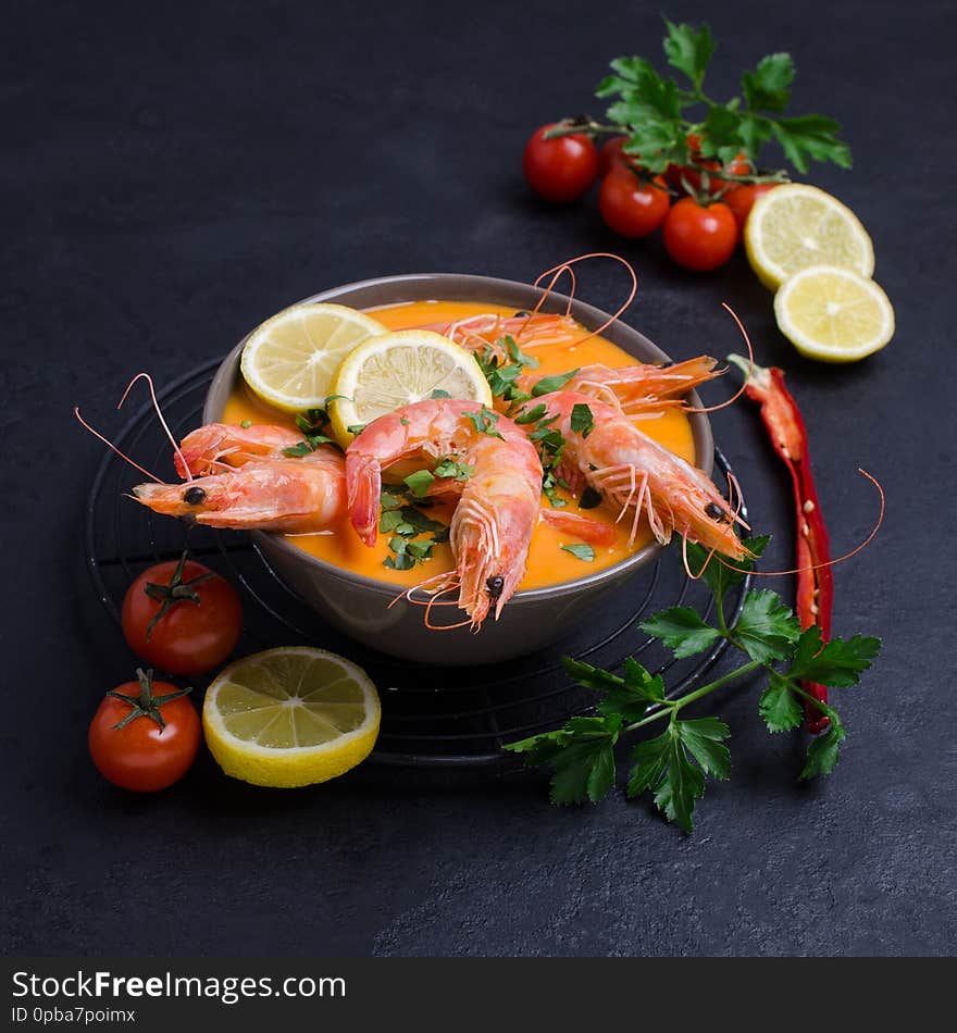 Traditional creamy soup with shrimp in a bowl on the table. Selective focus