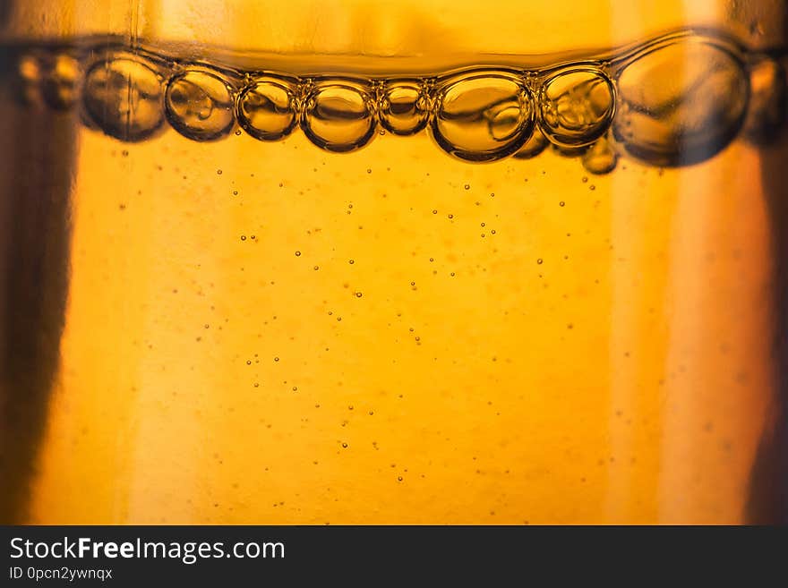 Closeup of medical liquid bubbles, golden colors background