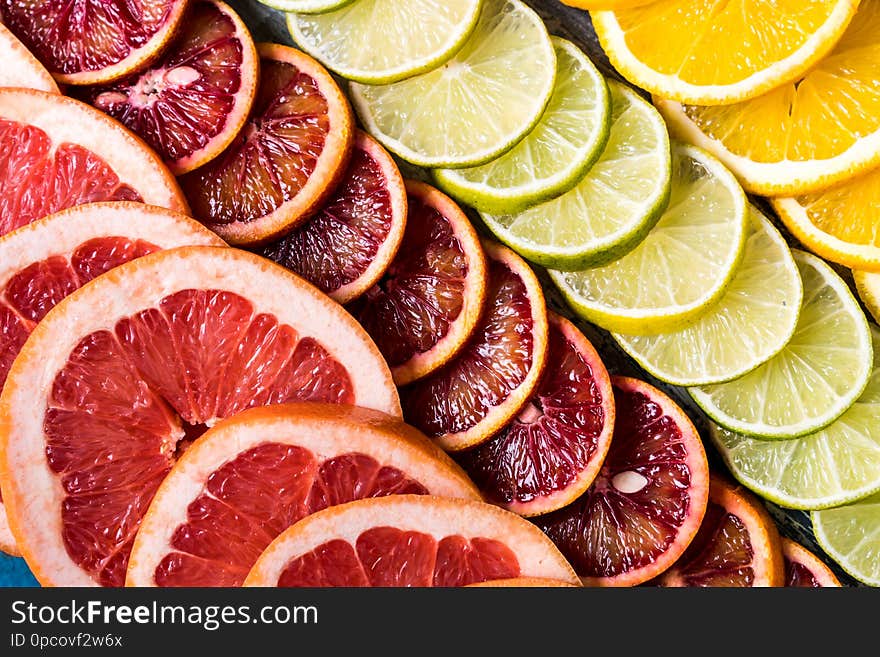 Healthy eating concept. Pattern with fresh slices of different Citrus fruit - yellow and red orange, lime, lemon and grapefruit. Flat lay. Healthy eating concept. Pattern with fresh slices of different Citrus fruit - yellow and red orange, lime, lemon and grapefruit. Flat lay