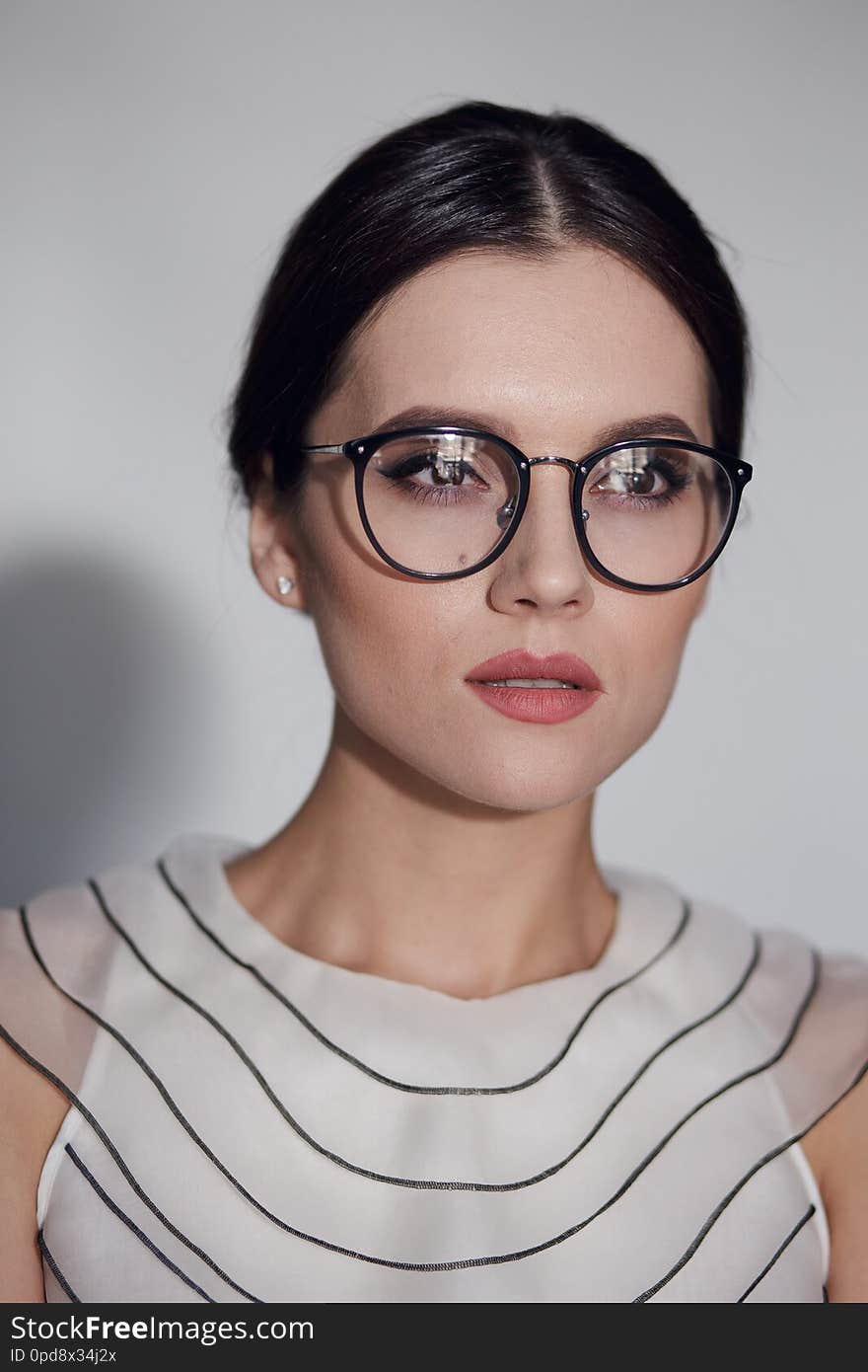 Beauty portrait of a young elegant woman in eyeglass, isolated on a white background. Vertical view.