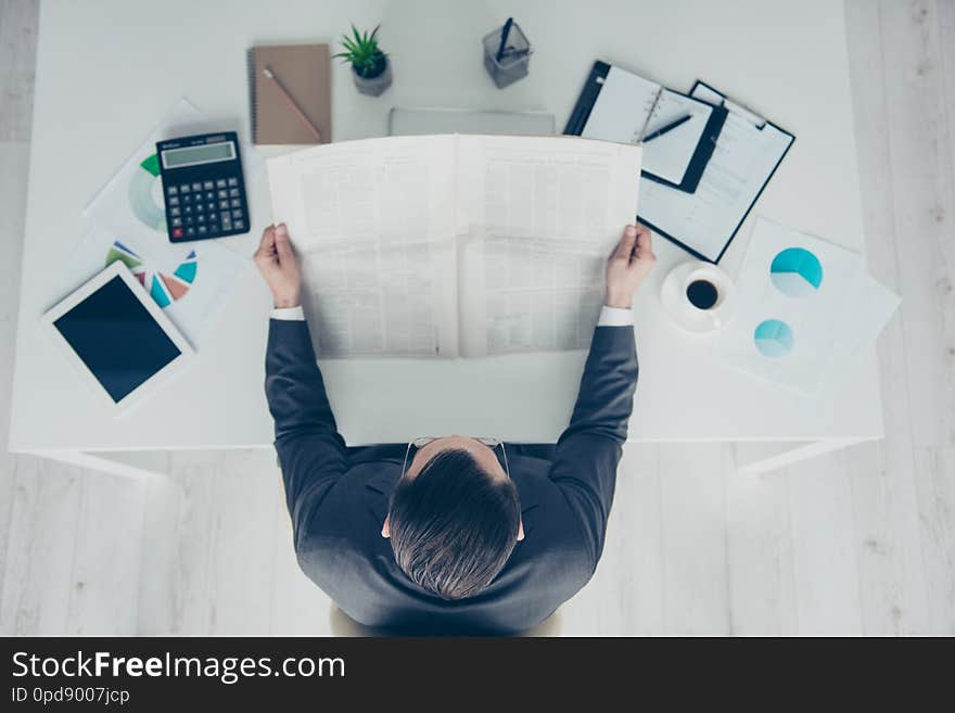 High angle above top view calm confident trendy style stylish imposing elegant classy chic man in formalwear sit behind desktop in bright lite office read column newspaper.