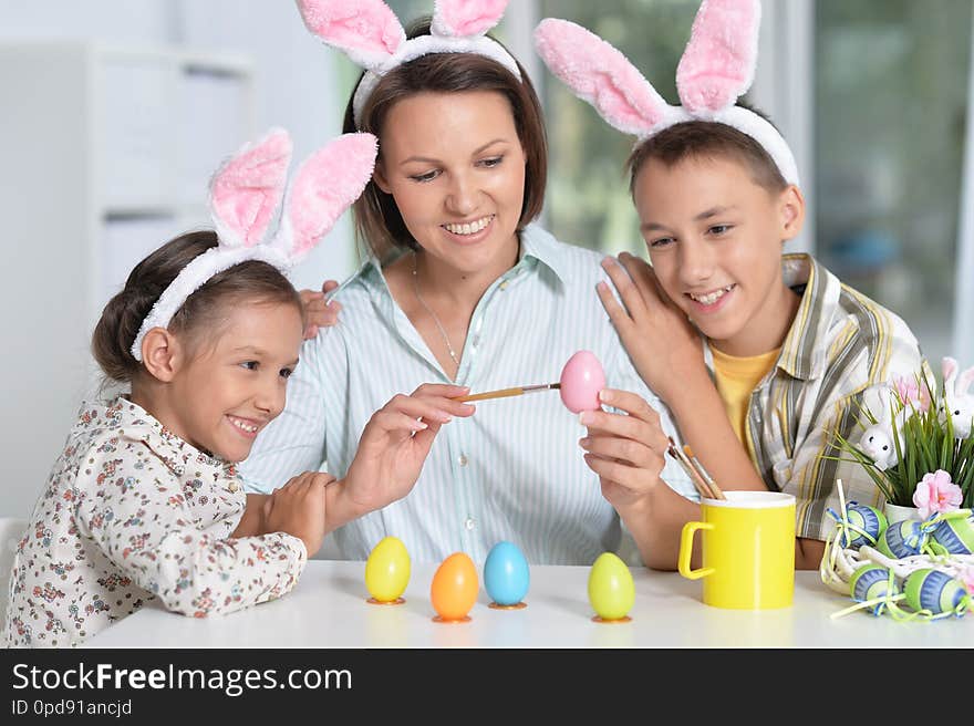 Portrait Of Family Painting Traditional Easter Eggs In Different Colors At Home