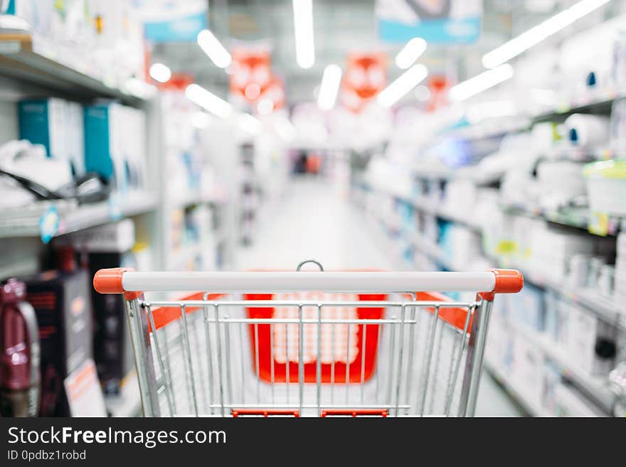 Empty cart in department of household appliances, supermarket. Trolley in market, nobody