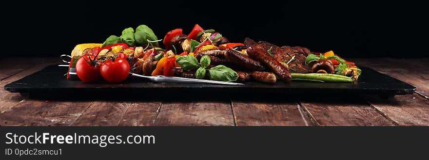 Assorted delicious grilled meat and skewer with vegetable on rustic table