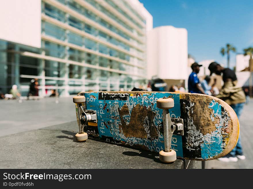 Close up of used skateboard in urban environment during sunny day with clear blue sky on wall