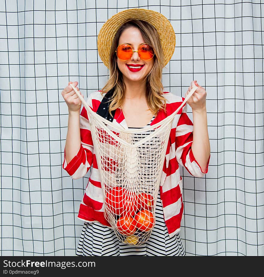 Smiling Woman In Hat And Striped Jacket With Net Bag