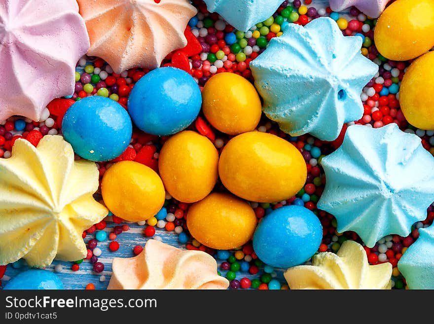 Blue wooden table full of candies, lollipops, cookies and sweet unhealthy food