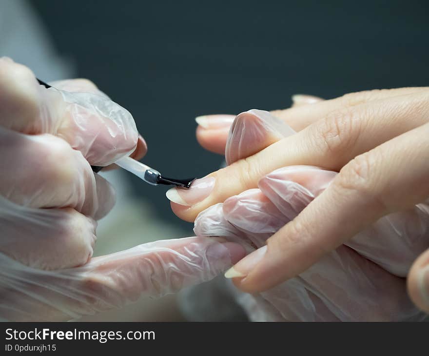 Applying nail Polish in the nail salon. Close up.