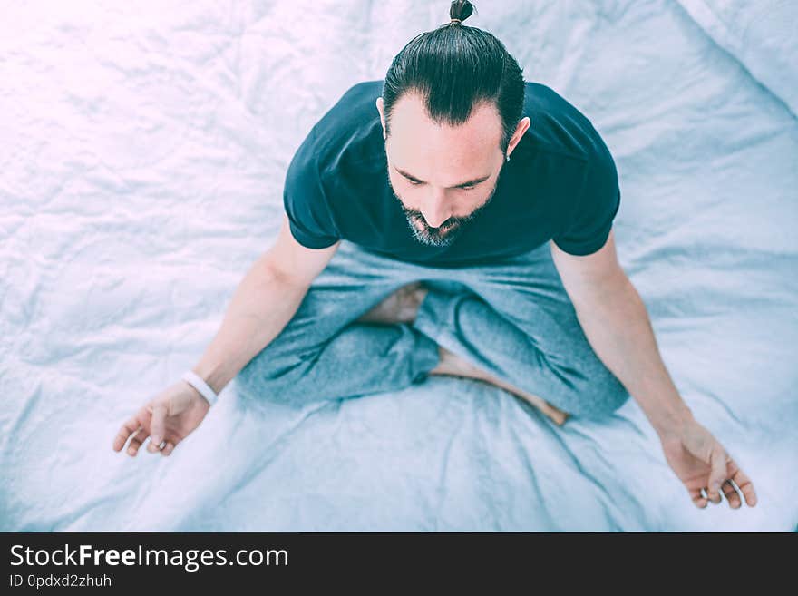 Peaceful relaxed man practicing yoga at home