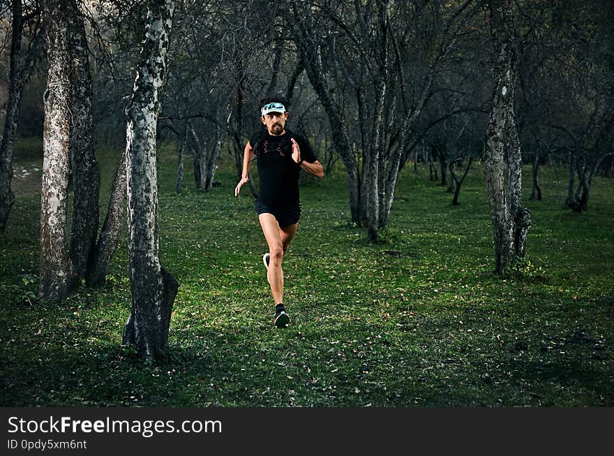 Fit man with beard running fast on the forest. Fit man with beard running fast on the forest