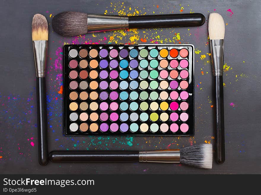 Flat Lay Of Colorful Eyeshadow Palette With Brushes On Black Background