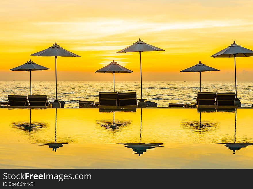 Umbrella and chair around swimming pool in resort hotel for leisure travel and vacation