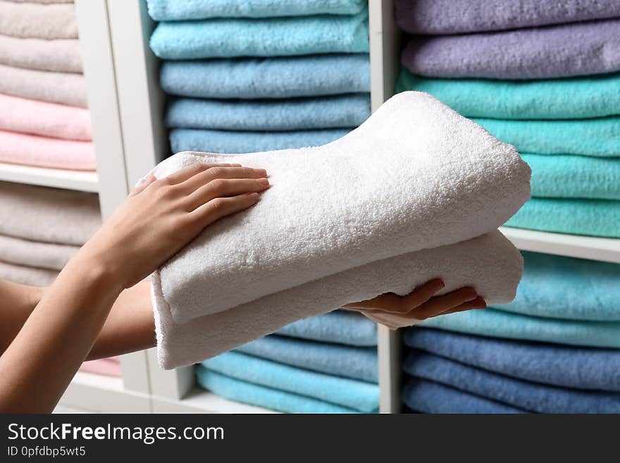 Woman holding towels near shelf