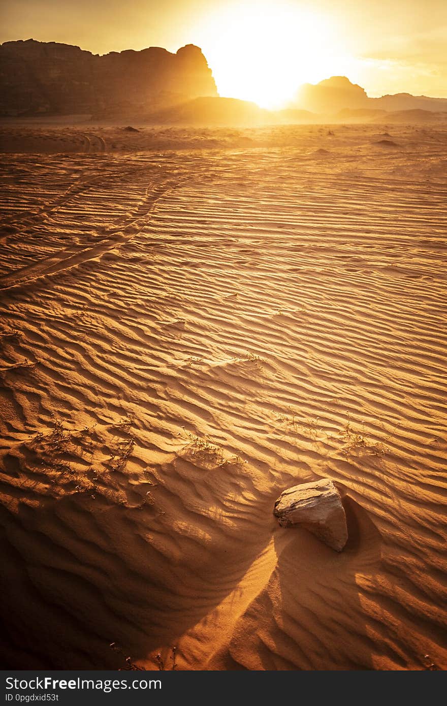 Landscape taken at the time of sunset, wadi rum desert, jordan, detail of sand dunes and rock in the foreground. Landscape taken at the time of sunset, wadi rum desert, jordan, detail of sand dunes and rock in the foreground