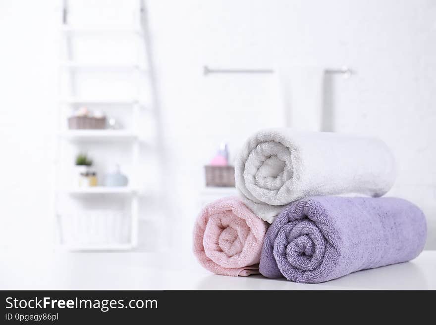 Rolled tidy towels on table in bathroom