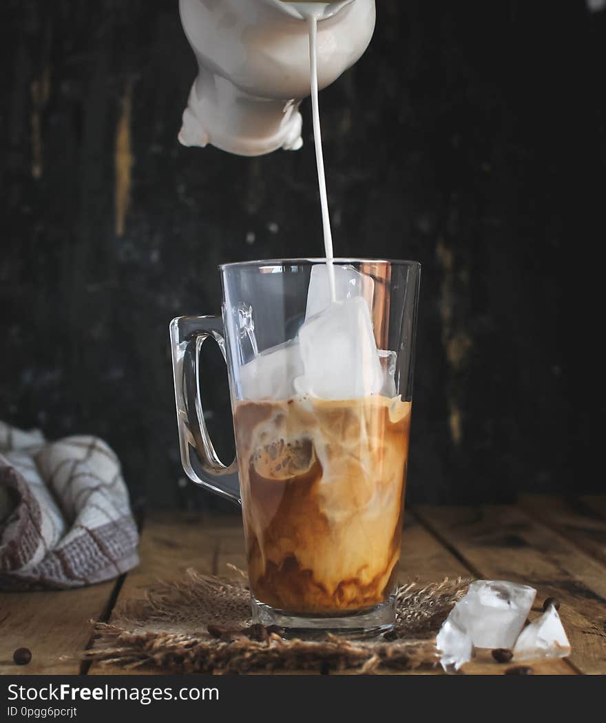 Ice coffee in a glass on wooden background