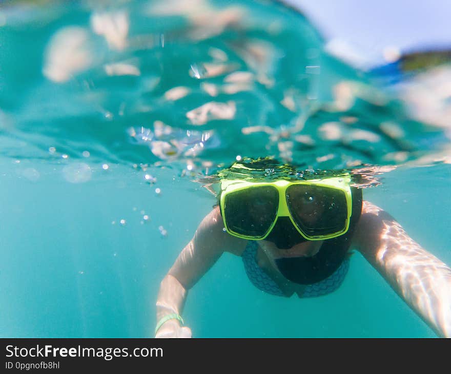 woman taking an underwater selfie while snorkeling in crystal clear tropical water