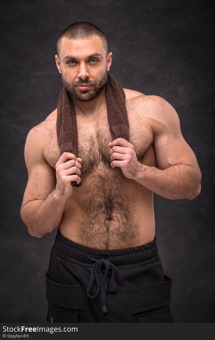 Young Muscular Bodybuilder Man Resting After A Hard Workout Training, Posing With A Towel