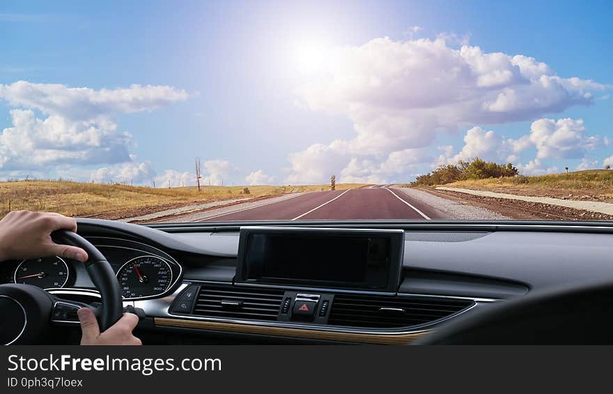 view from the car on a country highway illuminated by the sun