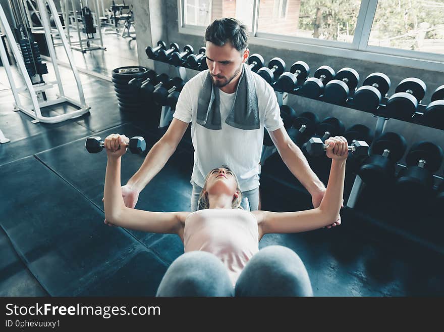 Beautiful Woman in Fitness Club and Trainer With Dumbbells Equipment, Portrait of Couple Love an Exercising Muscular Training in Gym., Sport and Healthy Concept