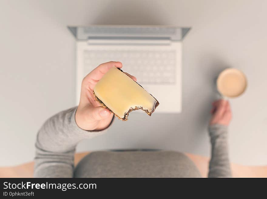 Woman having lunch break at workplace with coffee and cheese sandwich. Top view