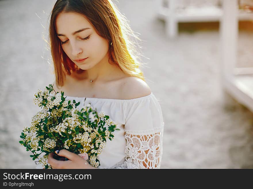 Beautiful girl with bouquet of flowers. Lady have fun in a summer park. Beautiful girl with bouquet of flowers. Lady have fun in a summer park